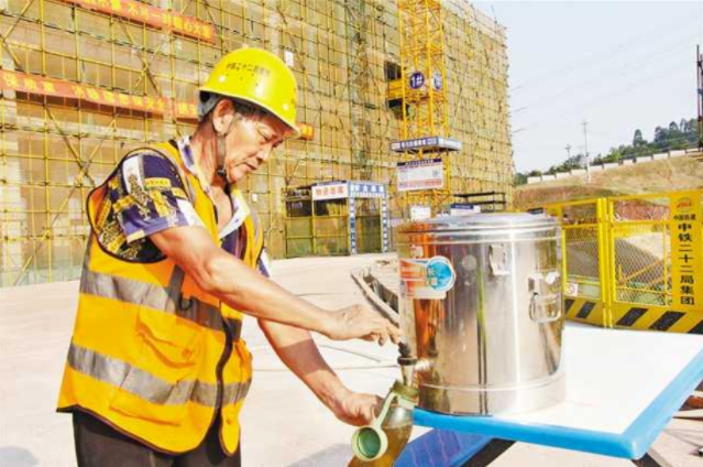施工人员正在接防暑降温茶水 图：重庆住建
