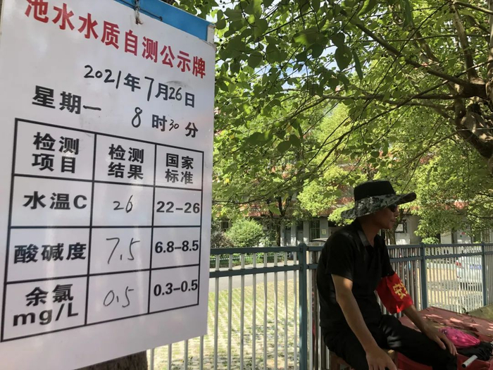 ▲7月26日，罗坊镇希望小学，救生员盯着泳池，旁边的白板用于记录水质。新京报记者 杜寒三 摄