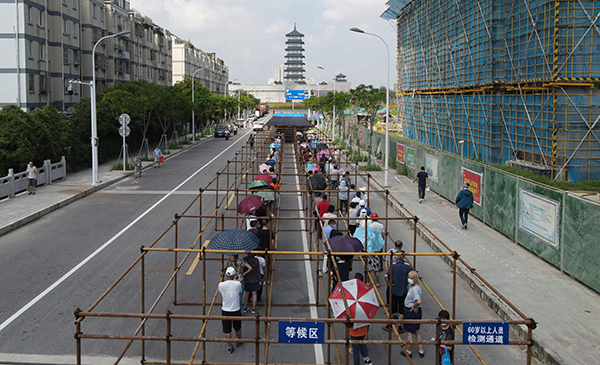 2021年8月7日，市民在江苏省扬州市广陵区汤汪乡杉湾花园社区核酸检测点排队等候核酸检测取样。人民视觉&nbsp; 图