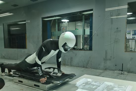 学生模拟运动员在北京交通大学风洞实验室进行风阻测试。 叶雨婷/摄