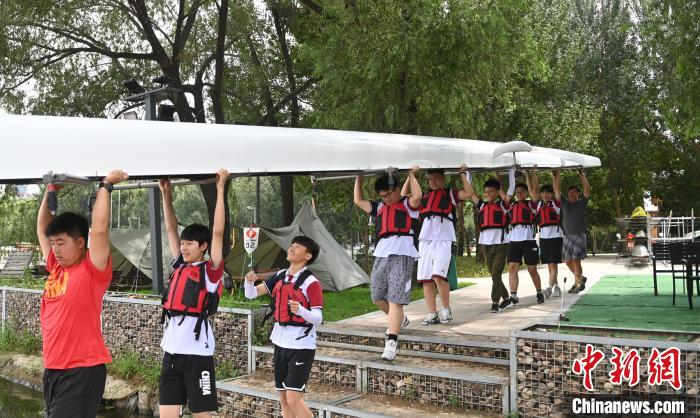 图为学员们扛艇下水。　于海洋 摄