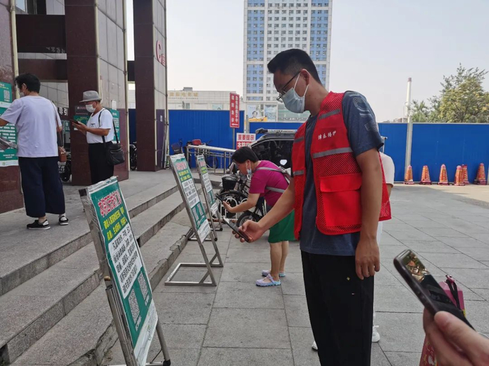 王中原正在天津市一家医院门口扫码登记。（记者白佳丽摄）
