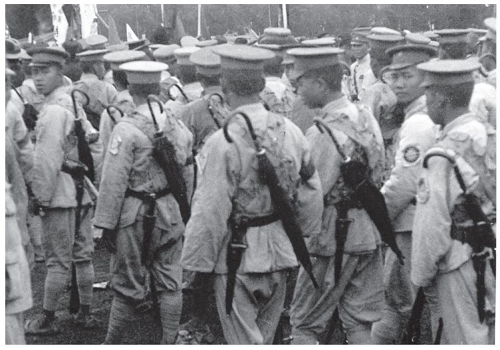 图a，身背雨伞行军的中国士兵