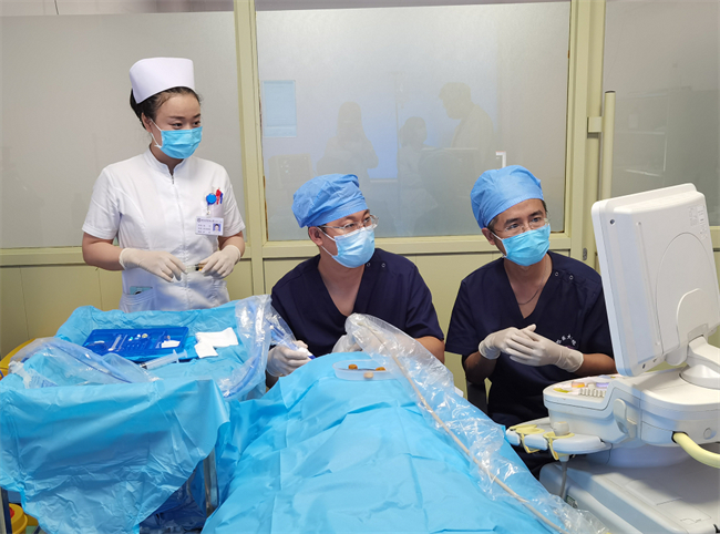 哈医大二院超声医学科姜双全副主任医师（中）、甲状腺外科孙宇副主任医师（右）、张艺护师（左）为患者进行超声引导下热消融治疗。哈医大二院 供图