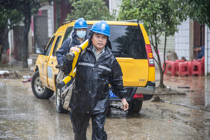 8月13日，电力工人在大雨中进行抢修作业。新华社记者 伍志尊摄