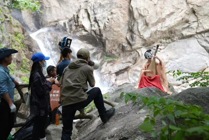 5月29日，《端午奇妙游》白云山外景拍摄幕后，演员正在弹奏琵琶。受访者供图