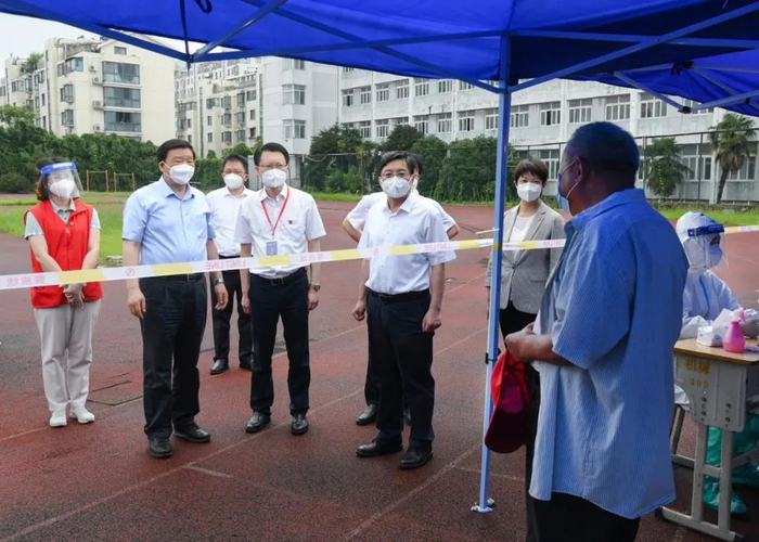 在扬州技师学院核酸检测采样点，娄勤俭向等候检测的居民了解核酸检测情况