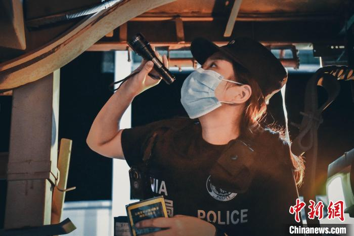 图为民警王卫正在检查车底。　王艳 摄
