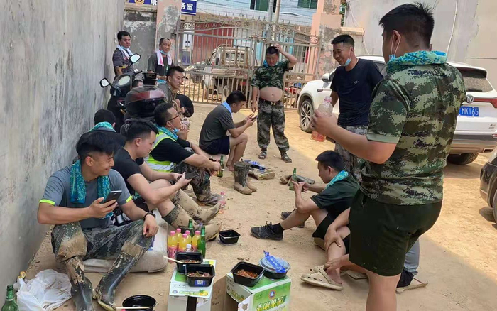 　8月，康店一中，队员在清理淤泥中休息。受访者供图