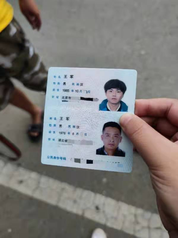 两位“王军”见面后拿出身份证相互确认姓名。新京报记者 慕宏举 摄