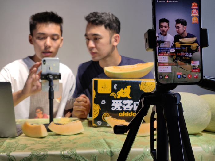 ▲早上11点，阿地力江·阿卜杜力来到办公室，与小伙伴们一起在拼多多平台直播销售哈密瓜，香甜的哈密瓜经常受到消费者点赞。周杭｜摄
