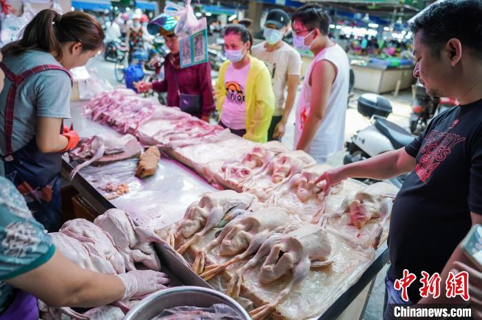 图为南宁淡村菜市，市民在家禽档口排队买鸭。　陈冠言 摄