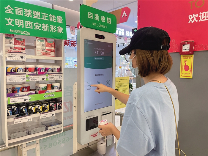  在西安市朝阳国际广场的一家超市，顾客正在使用自助收银系统结账。本报记者 付玉玮摄