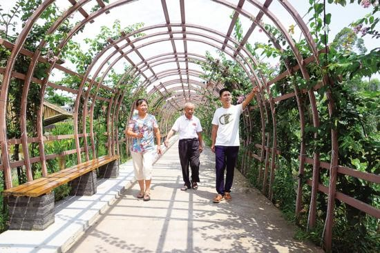 村民行走在美丽的花间小道。通讯员 胡丹 摄