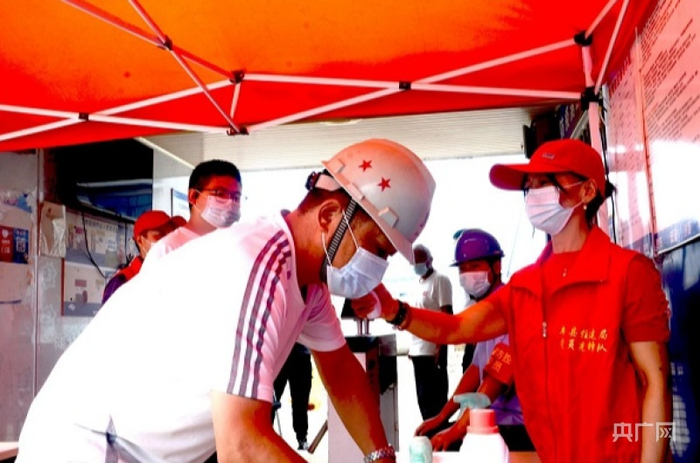 王云在工地上测量进场人员体温（央广网发 通讯员供图）