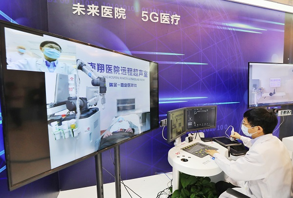 图说：瑞金医院医生通过远程控制5G机械臂，远程为病人进行B超 新民晚报记者 周馨/摄（下同）