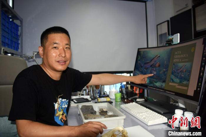 中科院古脊椎所盖志琨副研究员在办公室接受采访，介绍瓣齿鲨化石最新研究成果。　中新社记者 孙自法 摄