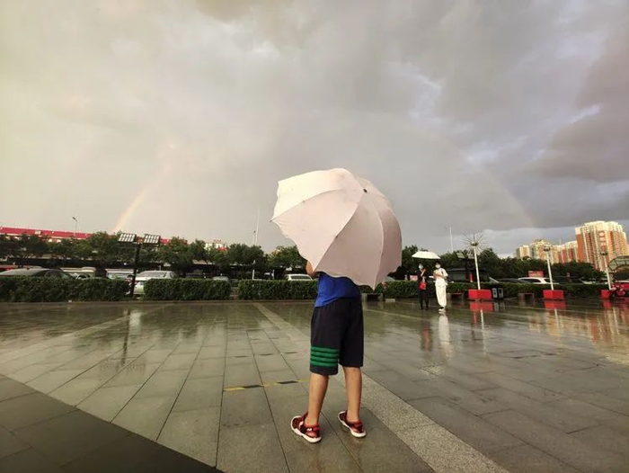 8月26日，丰台区看丹桥，小朋友在雨中看彩虹。傍晚一场雷阵雨过后，北京天空出现双彩虹。
