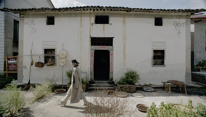 模特从《书记让房》典故的房子前走过 图片来源：ICICLE之禾