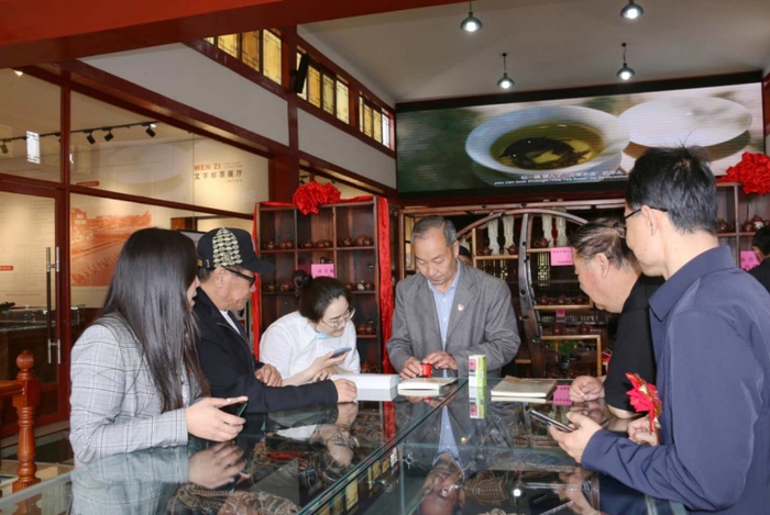 （游客在购买鸡鸣驿特色纪念封及明信片，打卡留念，企业供图，央广网发）