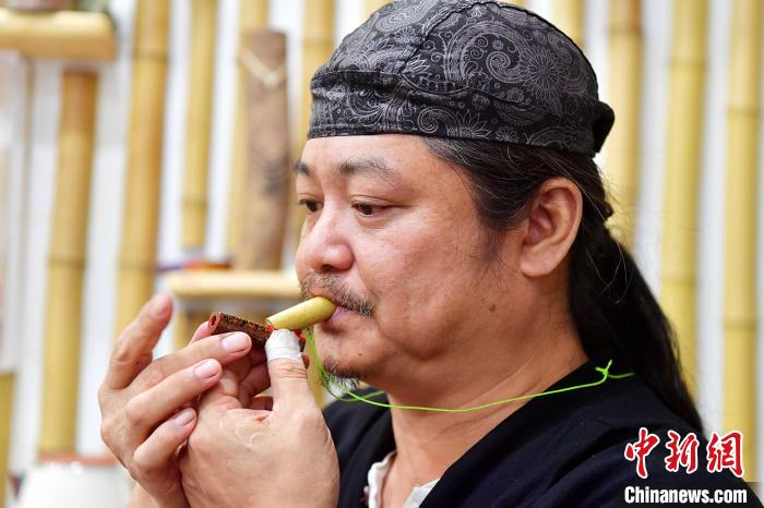 图为黄守堃正在展示自己制作的富有台湾特色的漆艺鸟笛。　张斌 摄
