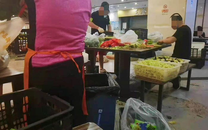 几名员工正在餐桌上切菜。