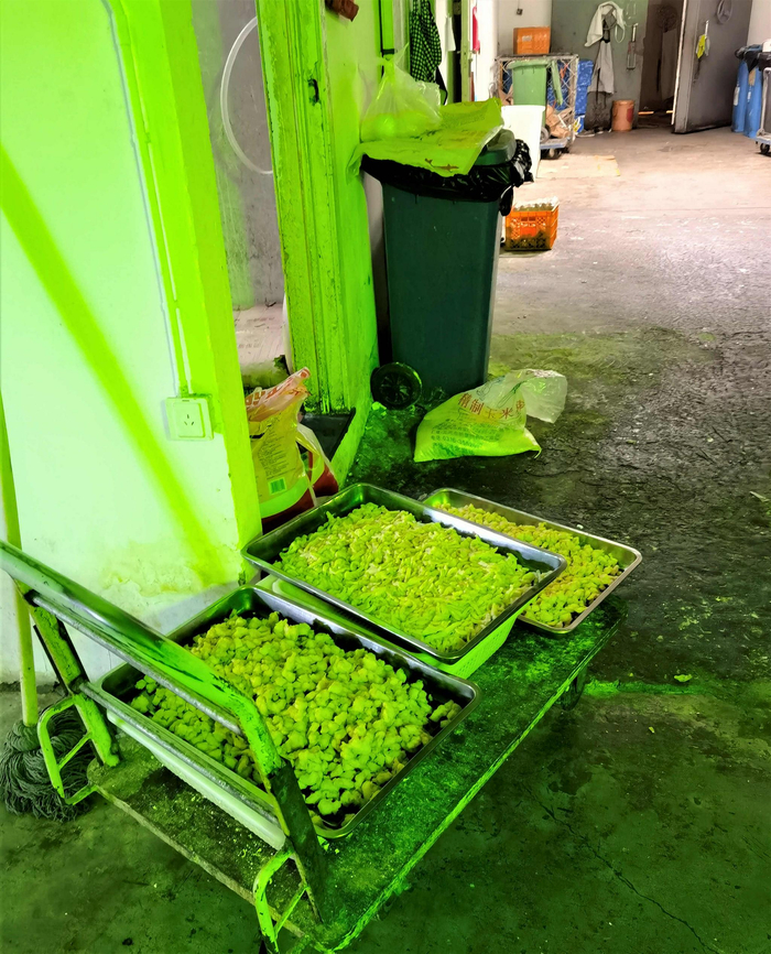 油炸食品摆在门口，旁边就是一个垃圾桶。