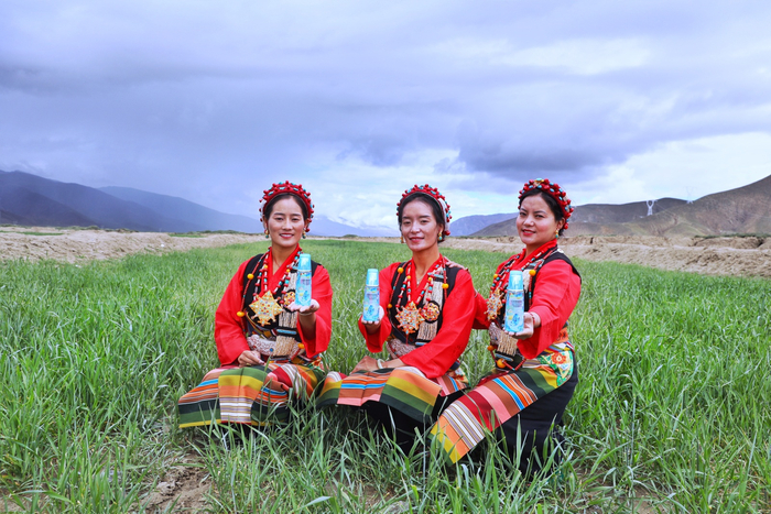 拉孜县生机勃勃的绿麦草中，藏族姑娘们获赠唐卡非遗传承人定制款冰肌水（央广网发 受访者供图）