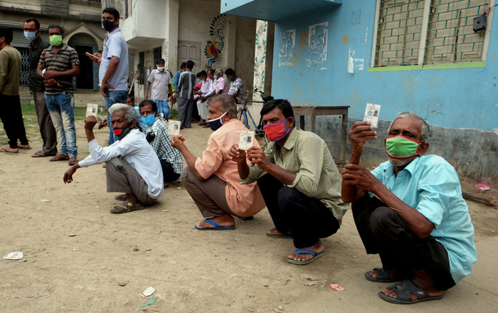 4月22日，人们戴着口罩在印度加尔各答郊区排队参加地方选举投票。新华社发