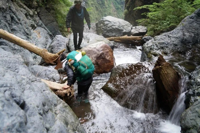 探险队员涉水翻越瀑布群。刘勇 摄