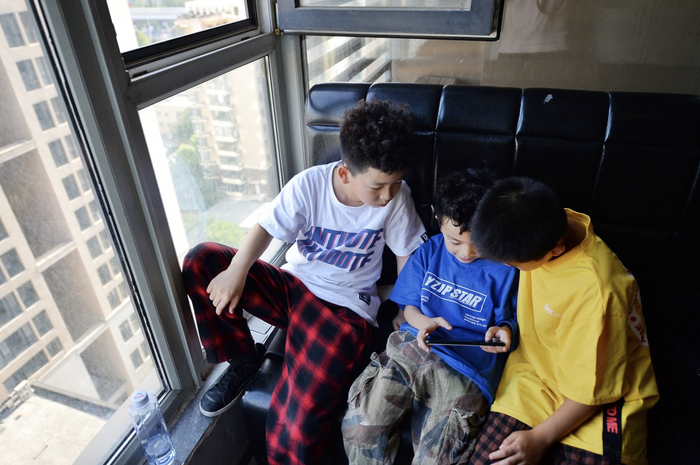 孩子们在街舞课的课间一起玩手机游戏。新京报记者 郑新洽 摄
