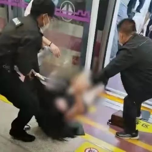 ▲女乘客被地铁安保人员拖拽至车厢外。事发视频截图