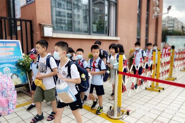 　　小学生在开学首日排队进入校园（央广网发 龚雯摄）