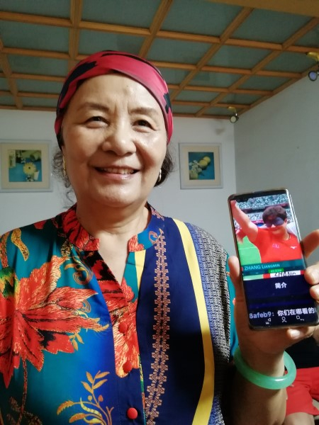 图说：母亲展示女儿的获奖照片