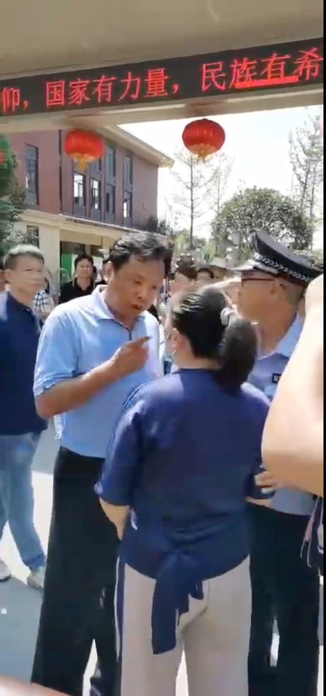 现场工作人员与学生家长沟通。 视频截图 