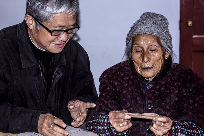 王五妮（右）捧着珍藏红军家属优待证（央广网发帅建忠提供）
