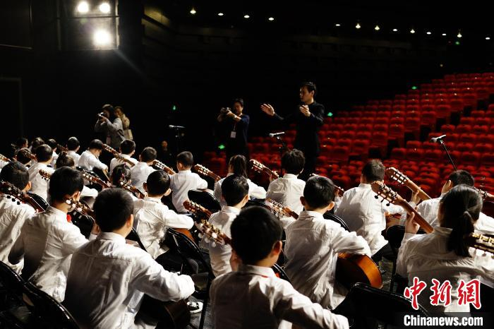 图为华启洋指导百人乐团排练。　华启洋供图