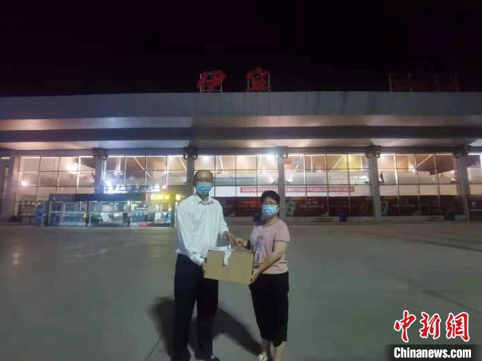 伊犁友谊医院工作人员接过装有医用粪菌活菌的箱子。　南航供图