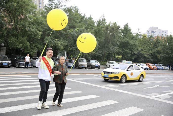 志愿者协助老人过马路（央广网发 陈鸿博摄）