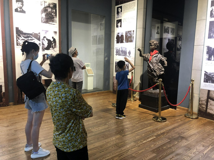 7月6日，重庆红岩魂陈列馆，一名小学生在小萝卜头雕像前敬少先队礼。新京报记者 张静姝 摄