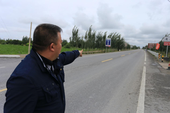  图：努尔麦麦提手指的方向，就是当年暴徒跟公安干警对峙的地方