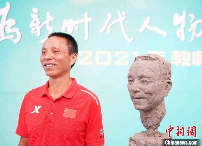 “全国教书育人楷模”之一的叶海辉与自己的塑像合影 史春阳 摄