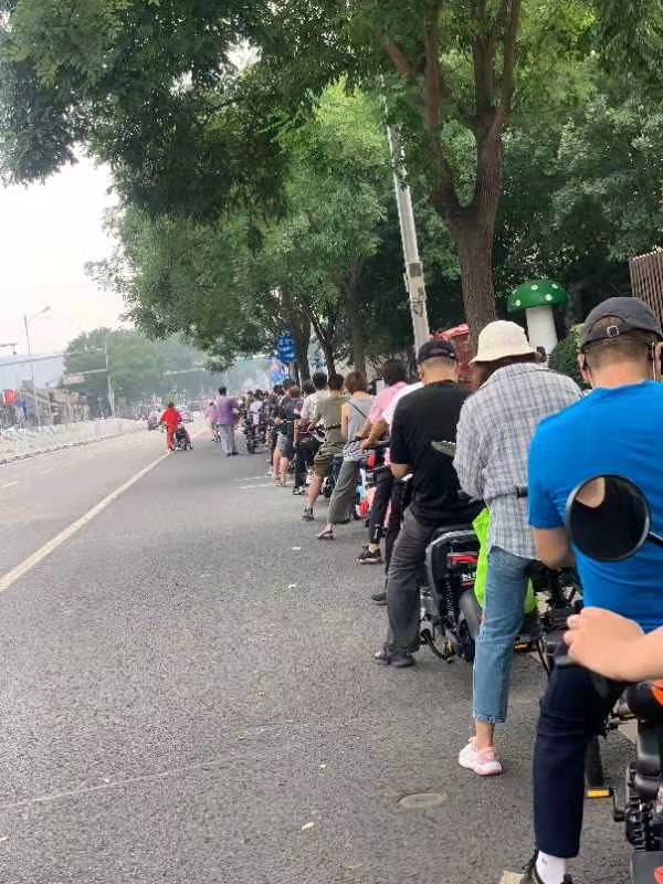 车管站外等待登记上牌的市民排起长龙。