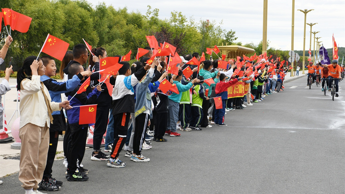 小朋友为参与骑行爱好者加油助威。