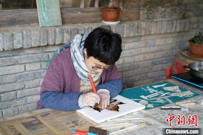 龙玉玉在正在制作叶雕作品。　受访者供图