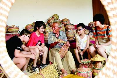 河北曲周白寨镇草编技艺传承人杨振国在家中向小朋友介绍草编技艺。新华社发