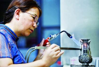 成都银花丝制作技艺传承人道安在制作双耳牡丹花瓶摆件。新华社发