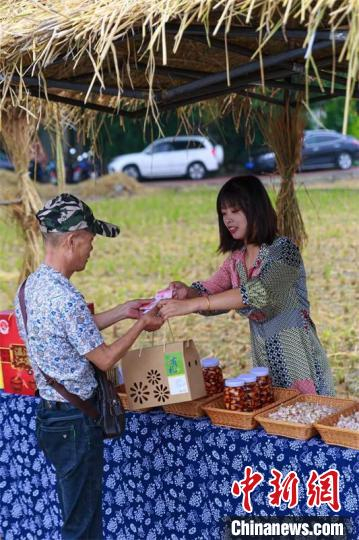 游客在稻海集市上购买商品。　陈加礼 摄
