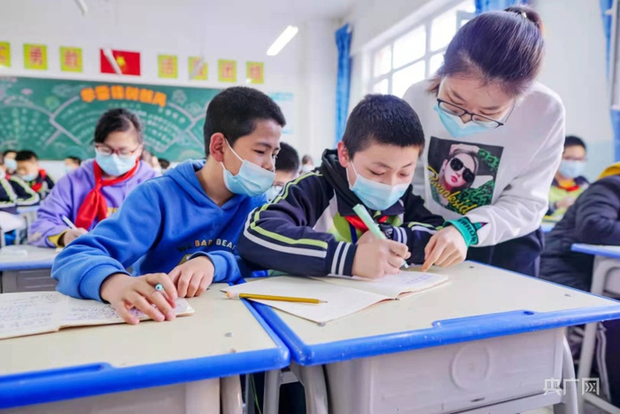 新疆昌吉市第六小学开展课后延时服务，老师为孩子辅导作业。杨斌摄央广网发