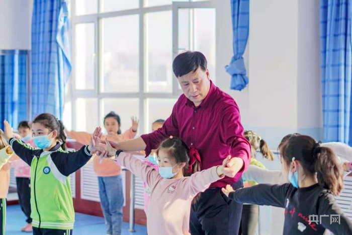 新疆昌吉市第六小学舞蹈老师为孩子上舞蹈课。杨斌摄央广网发